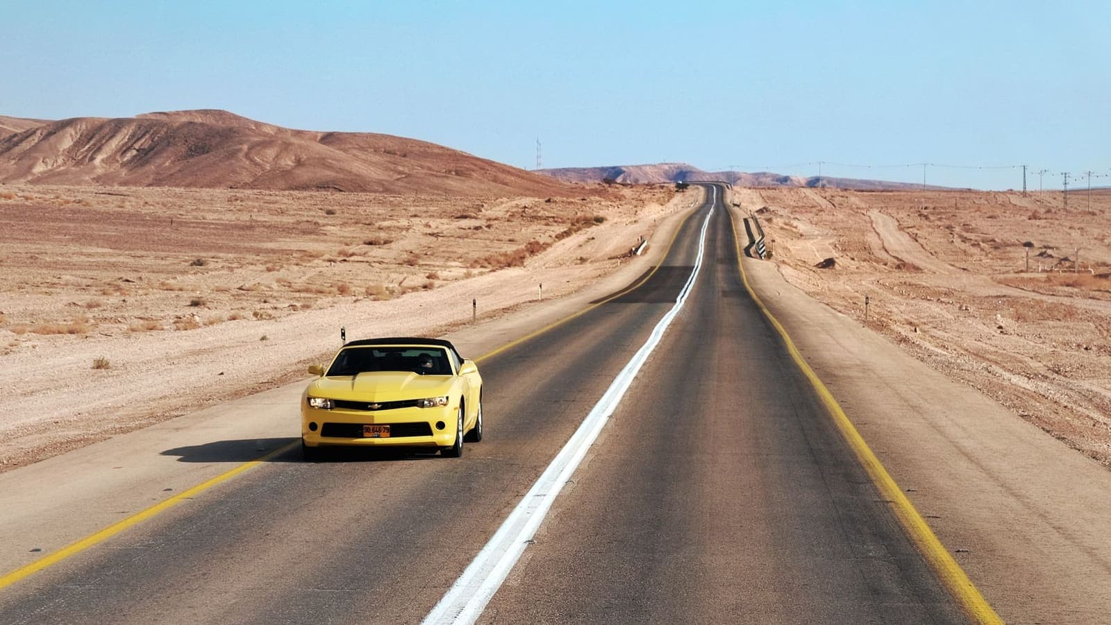 Auto op een droge asfaltweg in de zon