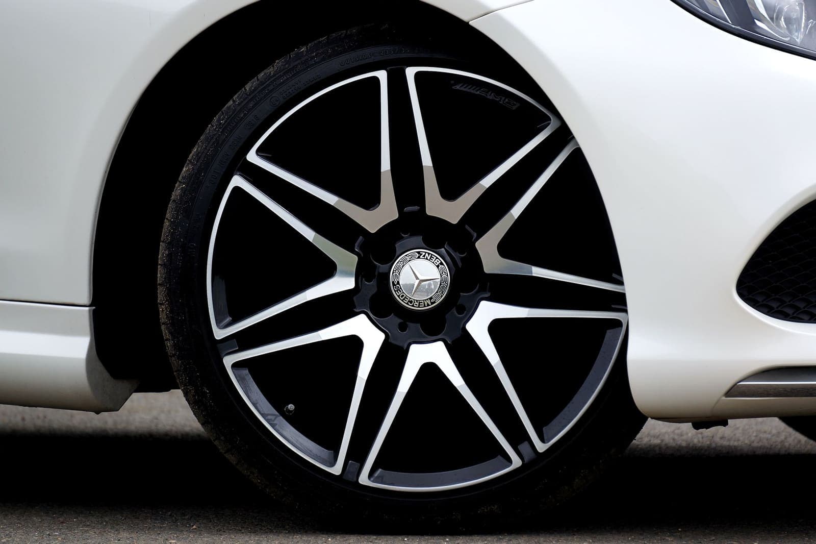 Lichtmetalen velg met donkere spaken op een lichtgekleurde auto
